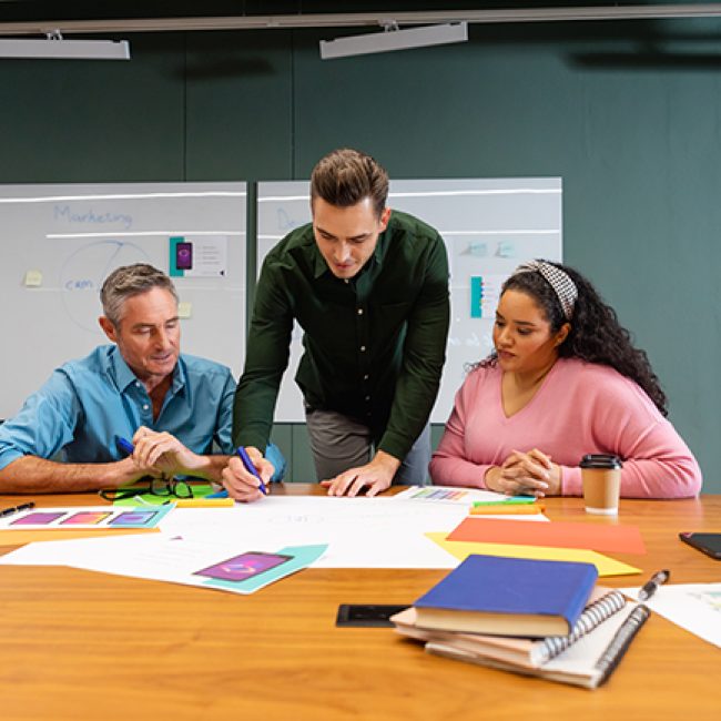 Multiracial businessmen and businesswoman discussing business strategy in meeting at creative office. Unaltered, creative business, workplace, discussion, diversity, planning, meeting.